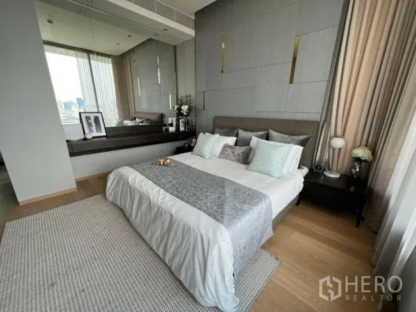 公寓 出租在Bang Rak, Bangkok - 主卧配灰色立面墙、镜面梳妆台与柔和窗帘。
