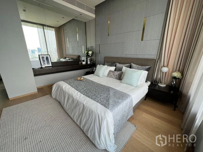 公寓 出租在Bang Rak, Bangkok - 主卧配灰色立面墙、镜面梳妆台与柔和窗帘。