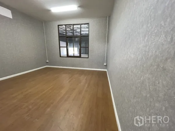 Warehouse for rent in Lam Luk Ka, Pathum Thani - Second office space with timber-look floor, large internal window and bright ceiling lights.