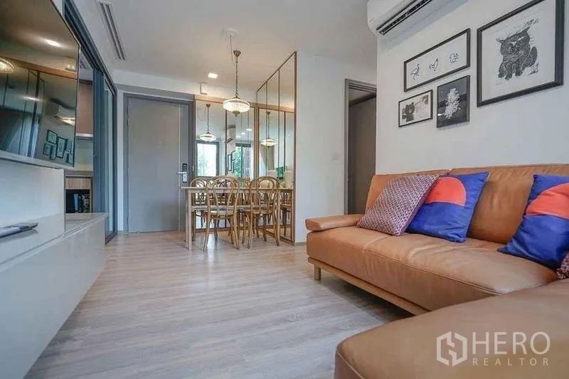 公寓 出租在Watthana, Bangkok - 客厅朝入口与镜面餐区的视角，空间通透明亮。
