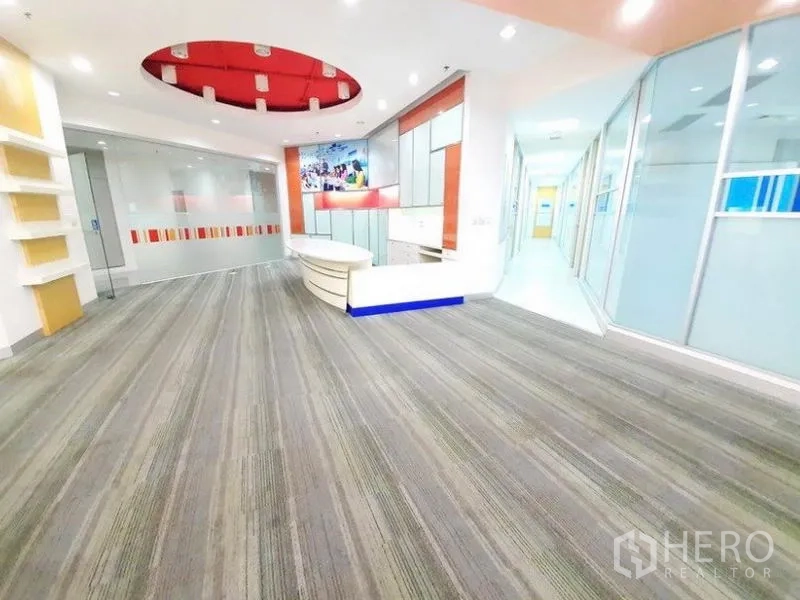 Office Space for rent in Bang Na, Bangkok - Wide view of the lobby showing the curved desk, glass partitions and a corridor leading to private rooms.