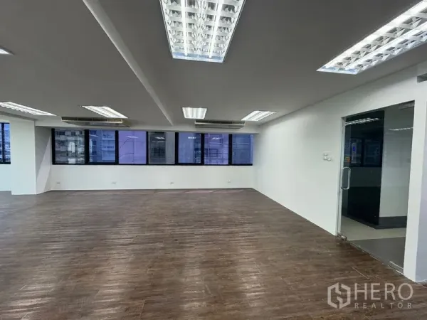 办公空间 出租在Sathon, Bangkok - 采光明亮的办公区，吊顶日光灯与玻璃入户门。