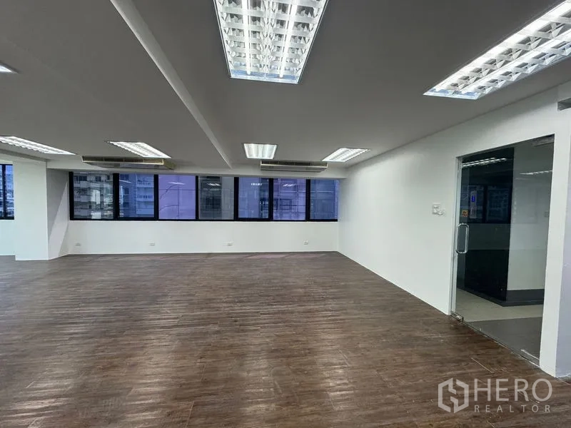 办公空间 出租在Sathon, Bangkok - 采光明亮的办公区，吊顶日光灯与玻璃入户门。