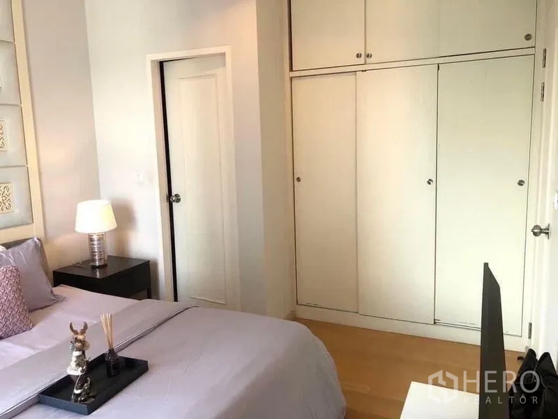 公寓 出租在Ratchathewi, Bangkok - 卧室一角，内置推拉衣柜与白色门。