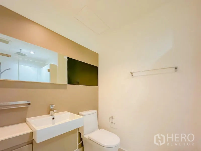 Condominium for sale - Minimalist bathroom with wall mirror, square basin and toilet in neutral tones.