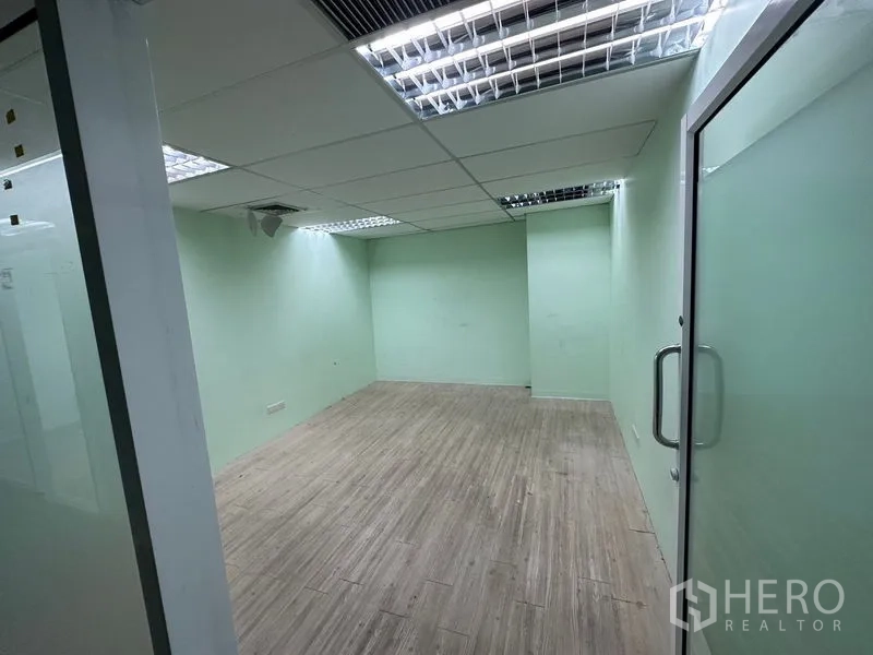 สำนักงาน ให้เช่า - ห้องประชุมปิดทึบ ประตูกระจกฝ้า ผนังโทนเขียวอ่อน และไฟฝังฝ้า