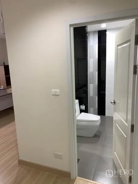 带办公室的家 出租或出售在Bang Na, Bangkok - 客用卫生间入口，白门与现代坐便器。