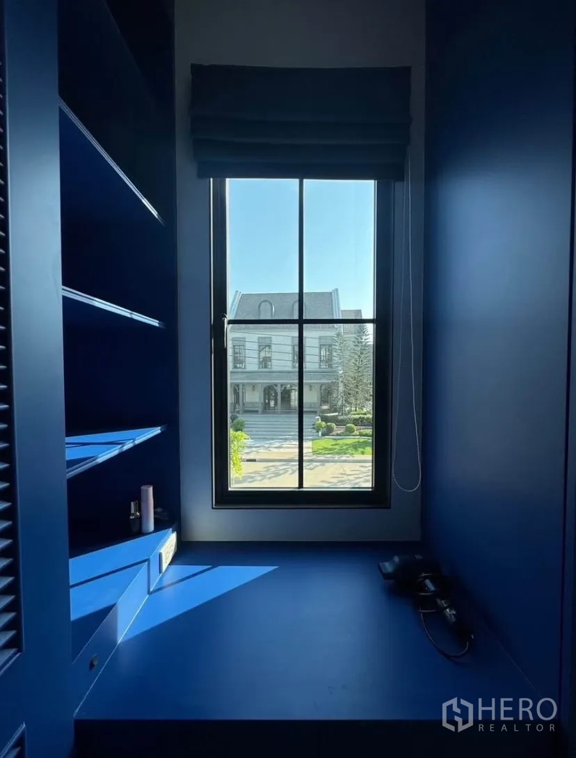Detached House for rent or sale in Lat Krabang, Bangkok - Compact window nook with built-in blue shelves and bench, overlooking the community avenue.