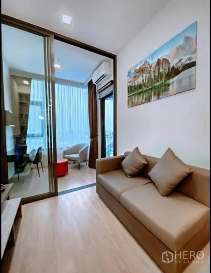 คอนโด ขายในHuai Khwang, Bangkok - ห้องนั่งเล่นสว่าง โซฟา ประตูกระจกบานเลื่อนและมุมทำงานริมหน้าต่าง ของคอนโดในห้วยขวาง กรุงเทพฯ
