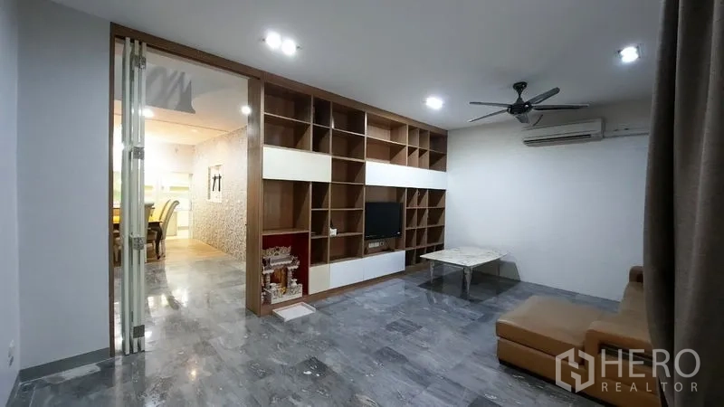 Townhouse for rent or sale in Suan Luang, Bangkok - Family room with wall-to-wall built-in shelving and marble-look floor.
