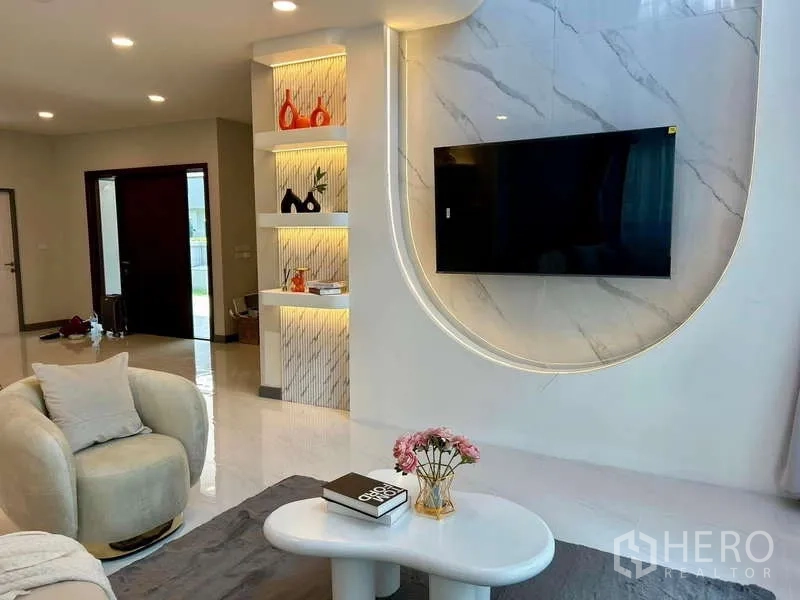 Detached House for rent in Bang Phli, Samut Prakan - Feature TV wall with marble finish and backlit display shelves in the living area.