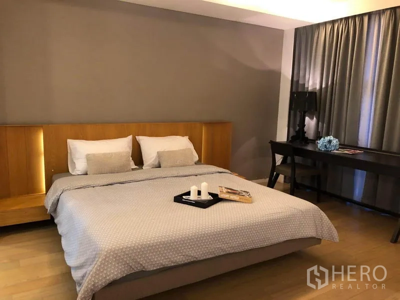 คอนโด ให้เช่าในWatthana, Bangkok - ห้องนอนอบอุ่น เตียงคิงส์ เฮดบอร์ดไม้ โต๊ะทำงาน และผ้าม่านสูงจรดเพดาน