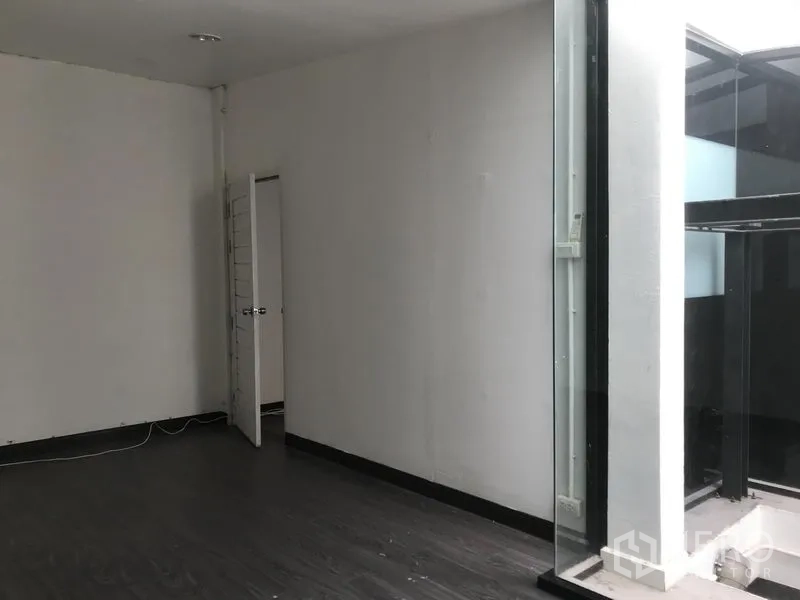 店屋 出租在Watthana, Bangkok - 明亮空间，面向室内玻璃采光井，深色地板与白墙