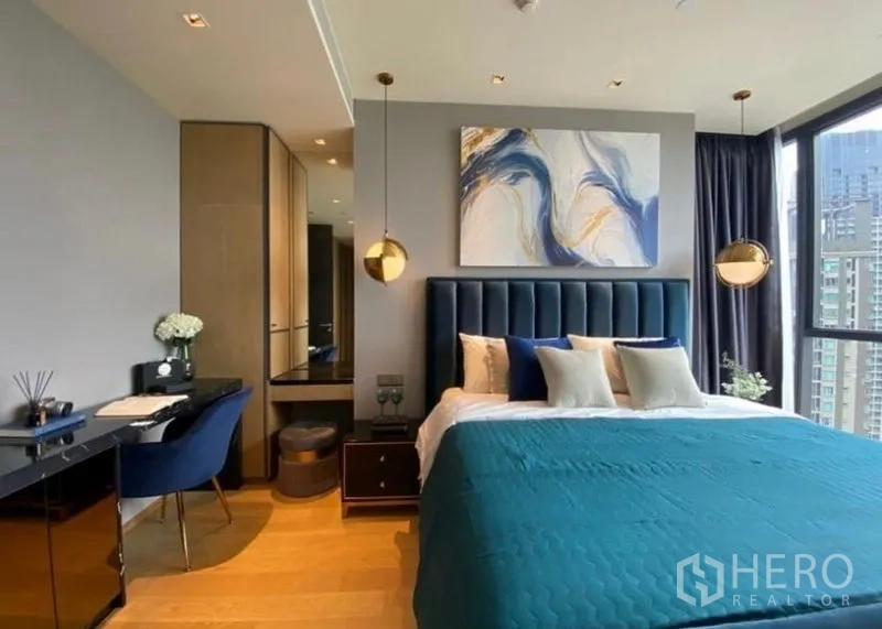 Condominium for rent - Second bedroom with deep blue upholstered headboard, writing desk and city views.