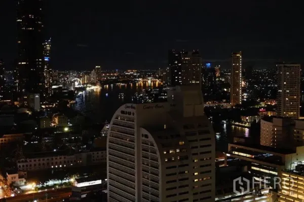Condominium for rent in Bang Rak, Bangkok - Night panorama of the Chao Phraya River and city skyline from a high-rise balcony.