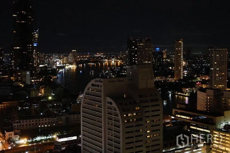 Condominium for rent in Bang Rak, Bangkok - Night panorama of the Chao Phraya River and city skyline from a high-rise balcony.