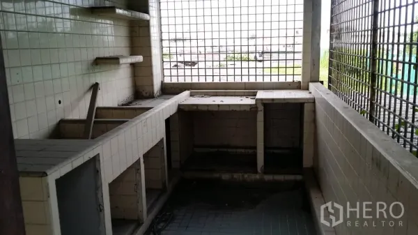 Office Space for rent in Don Mueang, Bangkok - Tiled utility area with built‑in counters and metal grille windows, suitable for a pantry or service room.