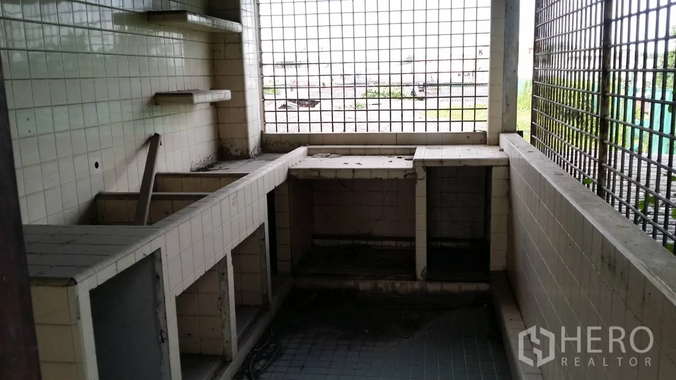 Office Space for rent in Don Mueang, Bangkok - Tiled utility area with built‑in counters and metal grille windows, suitable for a pantry or service room.