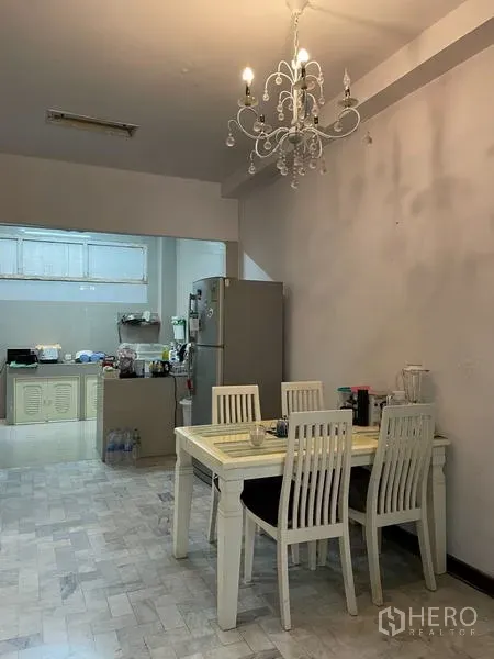 Home Office for rent in Ratchathewi, Bangkok - Dining space with chandelier beside an open kitchen and refrigerator.