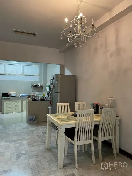 Home Office for rent in Ratchathewi, Bangkok - Dining space with chandelier beside an open kitchen and refrigerator.