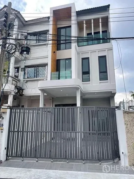 ทาวน์เฮาส์ ขายในWatthana, Bangkok - ด้านหน้าทาวน์เฮ้าส์สไตล์โมเดิร์น 3 ชั้น พร้อมระเบียงและประตูรั้วเลื่อน