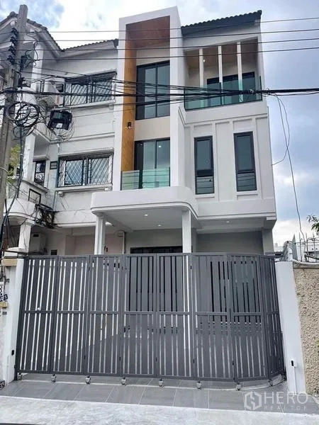 ทาวน์เฮาส์ ขายในWatthana, Bangkok - ด้านหน้าทาวน์เฮ้าส์สไตล์โมเดิร์น 3 ชั้น พร้อมระเบียงและประตูรั้วเลื่อน