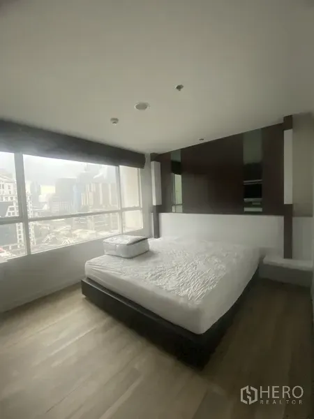 公寓 出租在Pathum Wan, Bangkok - 主卧配大床与整墙装饰，落地窗采光充足，可观曼谷城市景观的公寓。