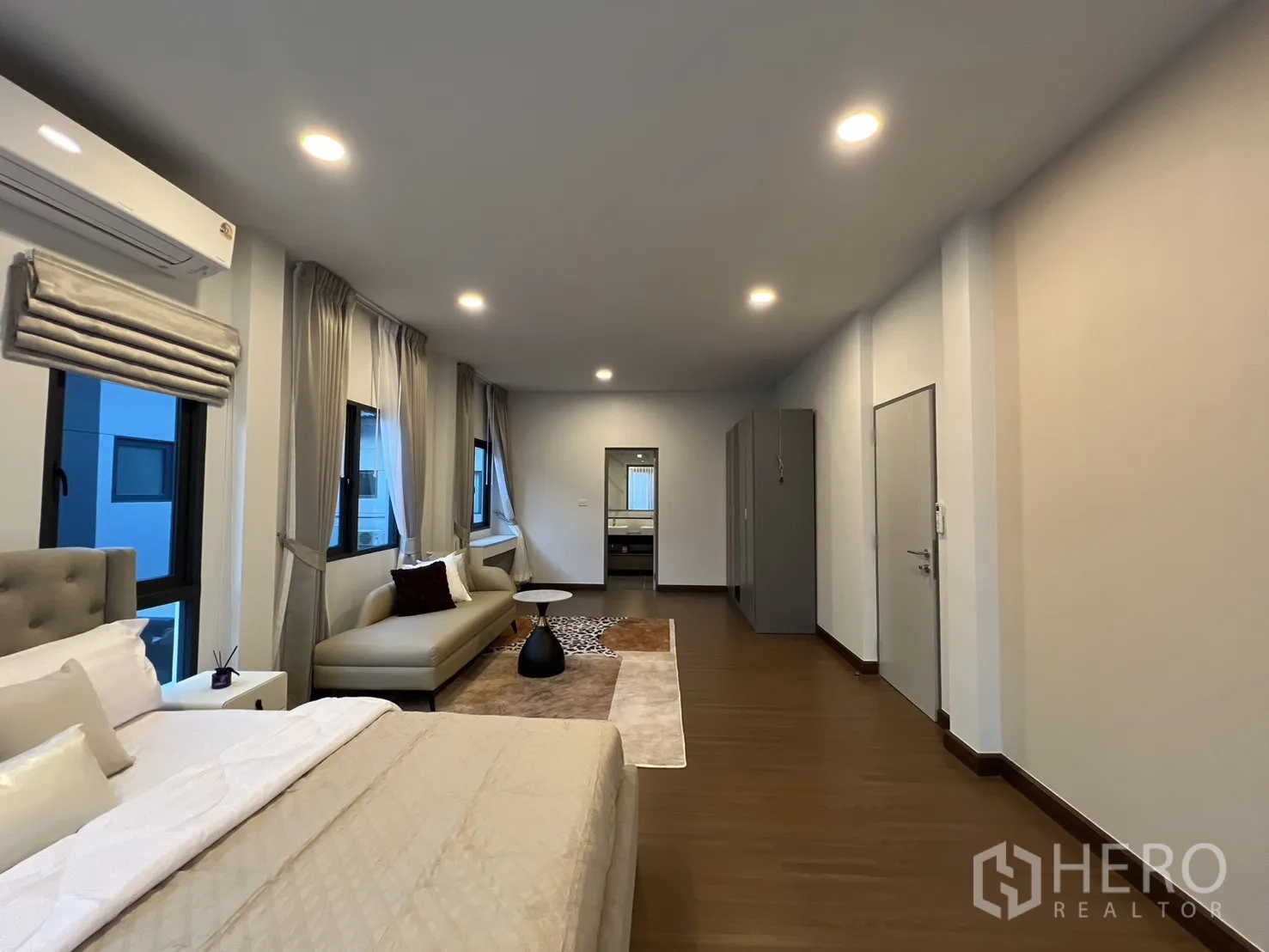 Detached House for rent in Bang Phli, Samut Prakan - Wide angle of master suite with bed, long sofa and wardrobes.