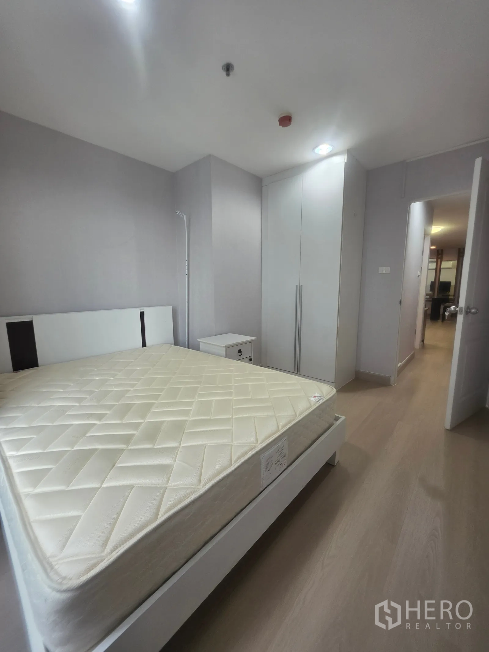 Condominium for rent in Huai Khwang, Bangkok - Bedroom featuring a bed and tall white wardrobe along the wall.
