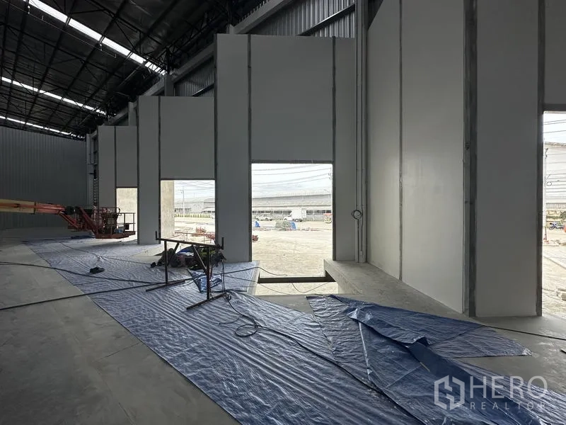 工厂 出租在Khlong Luang, Pathum Thani - 仓库内部，面向场地的高大开口与夹芯墙板结构。