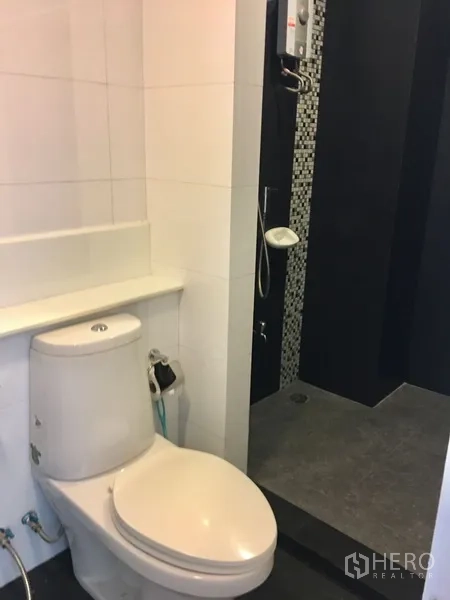 Condominium for rent in Watthana, Bangkok - Bathroom with walk-in shower, mosaic accent and toilet.