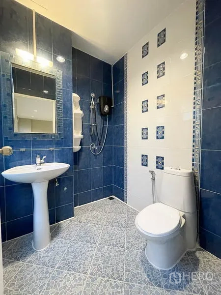 Townhouse for rent in Yan Nawa, Bangkok - Blue-and-white tiled bathroom with walk-in shower, pedestal sink and toilet.