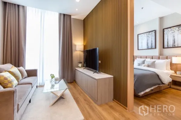 公寓 出租在Watthana, Bangkok - 开放式客厅，电视柜与栅格特色墙，旁边是卧室