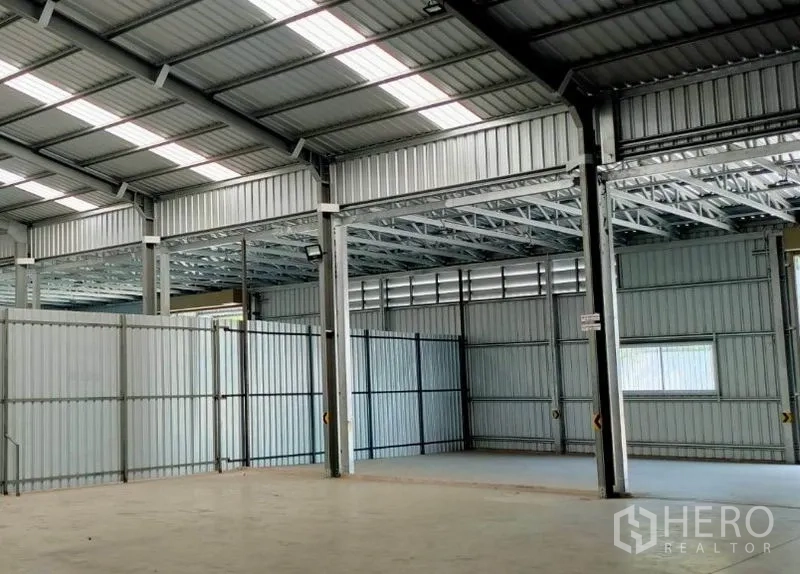 货栈 出租在Pak Kret, Nonthaburi - 多跨仓库区域，钢立柱、百叶通风口与隔断墙。