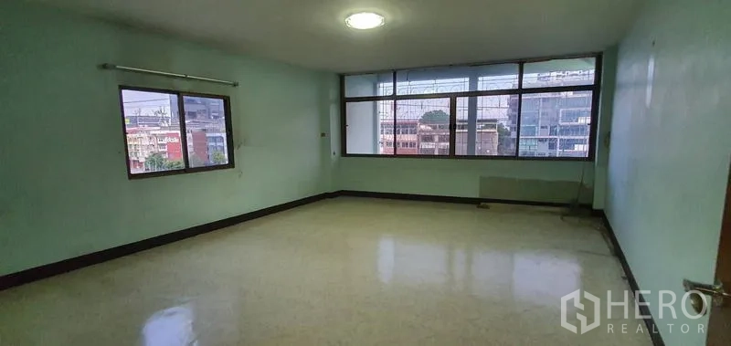 Warehouse for rent in Bang Kho Laem, Bangkok - Large office room with wide windows, glossy floor, and urban outlook.