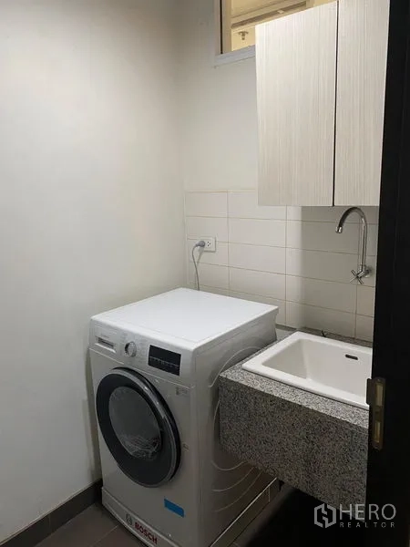 公寓 出租在Watthana, Bangkok - 紧凑洗衣间，配博世洗衣机、洗衣池与吊柜。