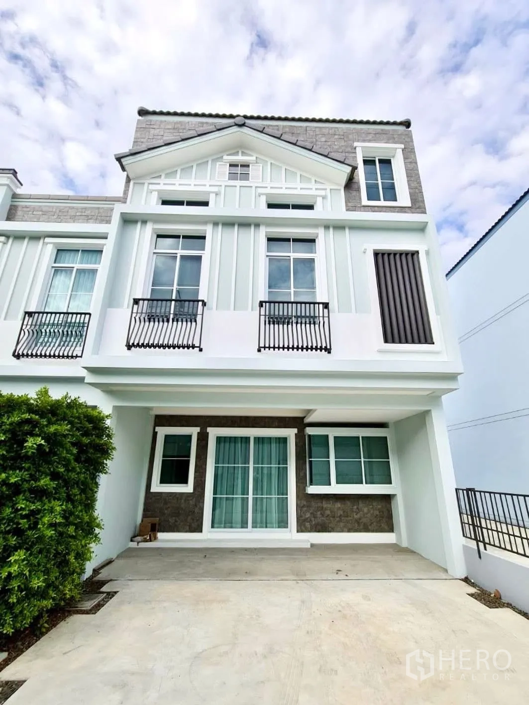 联排别墅 for rent in Prawet, Bangkok - 三层联排别墅外立面，带车棚与白框窗户。