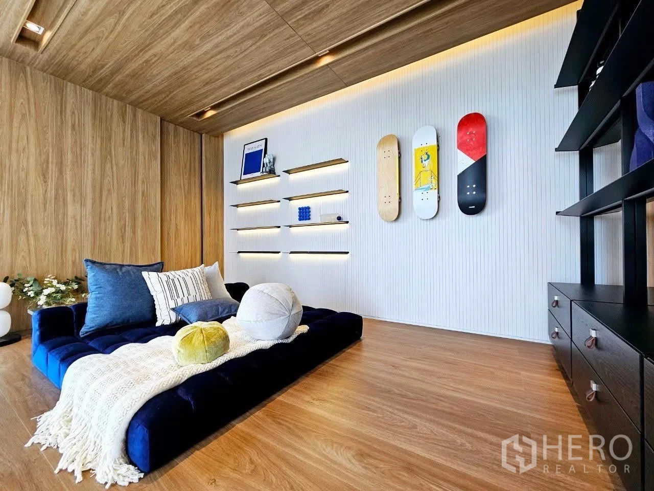 Detached House for rent in Saphan Sung, Bangkok - Light-filled loft lounge with velvet sofa and floating shelves.