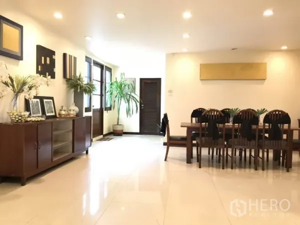 Detached House for rent in Phra Khanong, Bangkok - Spacious dining area with a long wooden table, sideboard, and recessed ceiling lights.