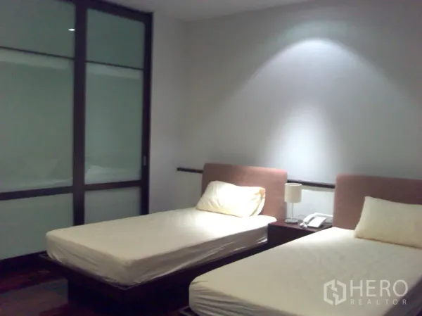 คอนโด ให้เช่าในWatthana, Bangkok - ห้องนอนเตียงเดี่ยวคู่ แสงไฟนุ่มนวล พื้นไม้ และตู้เสื้อผ้าบานเลื่อนกระจกฝ้า