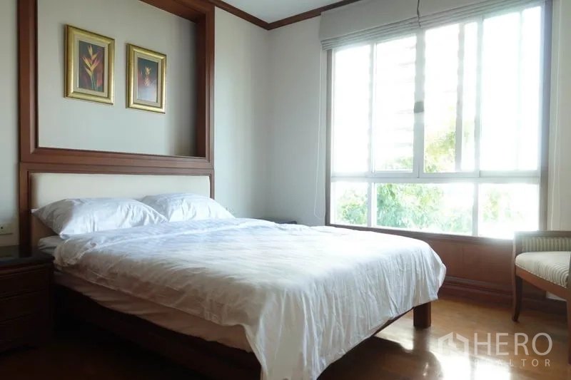 公寓 出租在Khlong Toei, Bangkok - 采光充足的卧室，大窗与简约木质家具。