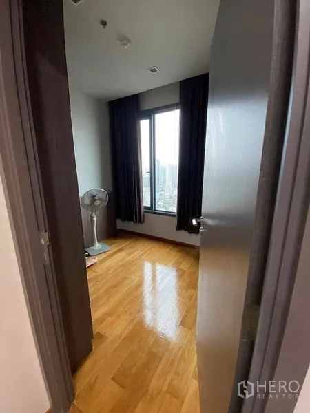 Condominium for rent or sale in Khlong Toei, Bangkok - Compact second bedroom or study with big window, blackout curtains and skyline outlook.