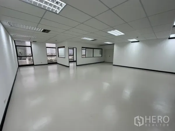 Office Space for rent - Bright open office floor showing city views through windows and grid ceiling lighting.