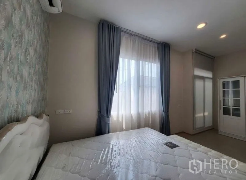 Townhouse for rent or sale - Bright master bedroom with large window, sheer and blackout curtains, upholstered bed and recessed lighting.