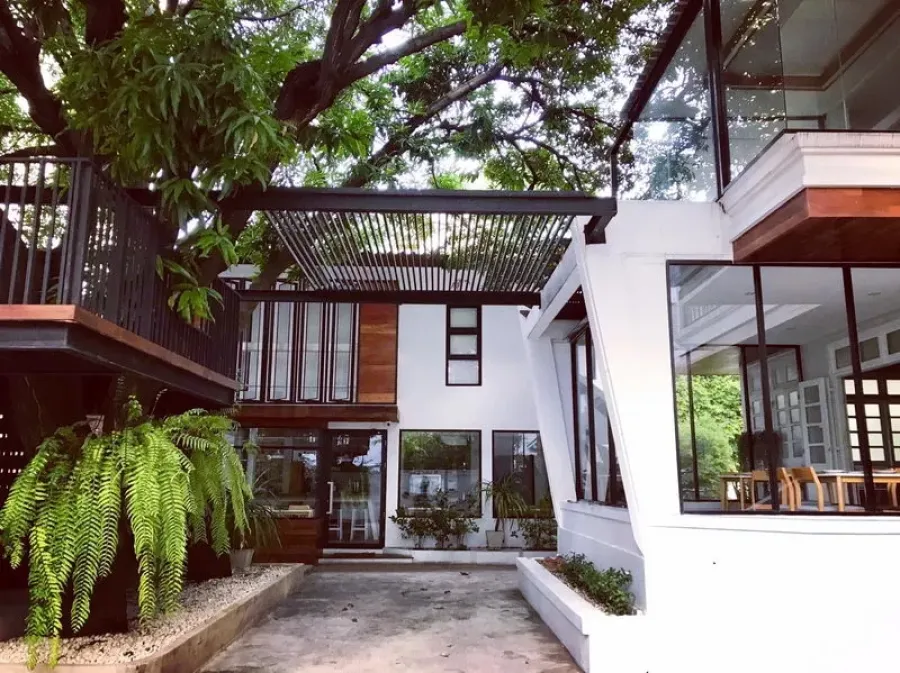 Retail Space for rent in Bang Rak, Bangkok - Modern two-storey retail building with glass walls, wood accents and a shaded courtyard beneath mature trees in Silom, Bang Rak.