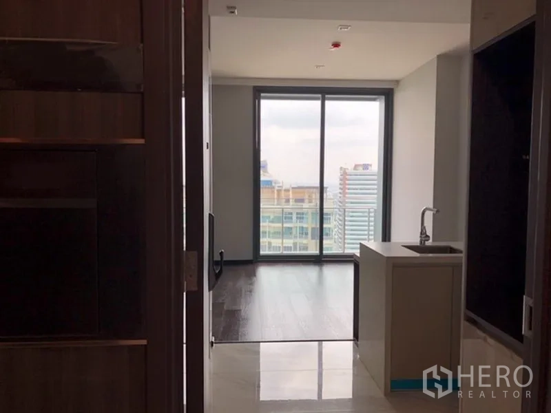 公寓 出售在Watthana, Bangkok - 入户走廊通向客厅与阳台，右侧为小厨房台面。