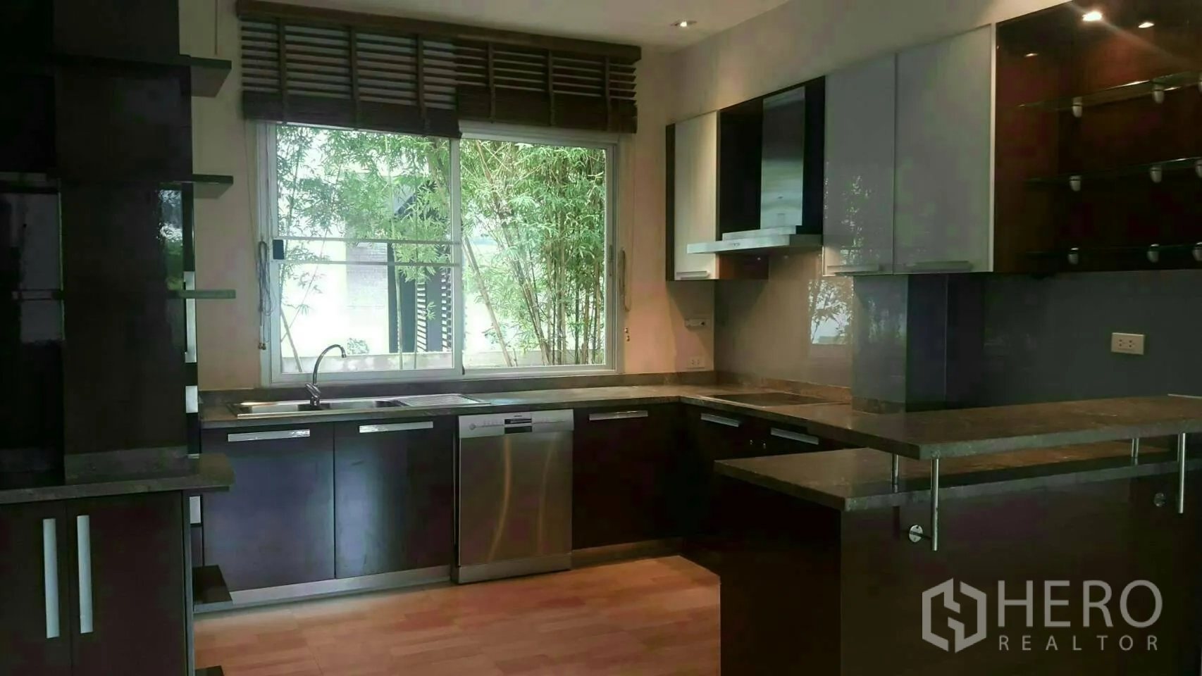 独立式住宅 出租或出售在Prawet, Bangkok - 现代U形厨房，大窗、深色橱柜与不锈钢家电