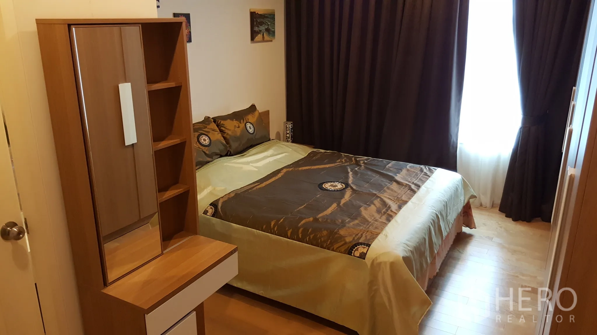 公寓 出租或出售在Ratchathewi, Bangkok - 温馨卧室，双人床、木质梳妆台与衣柜，木地板和遮光窗帘。