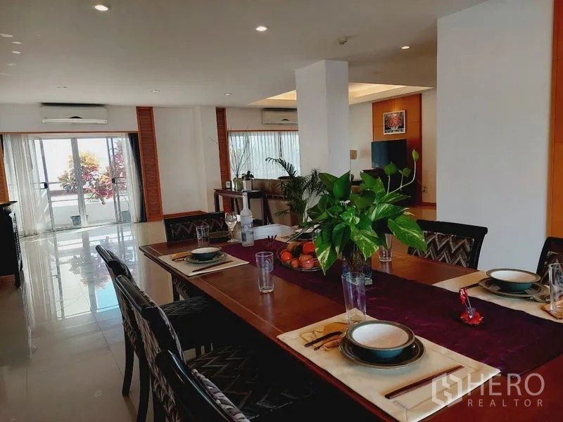 Apartment for rent - Dining room set for six with greenery and sliding doors to the terrace.