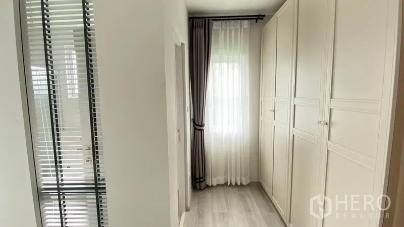 联排别墅 出租在Prawet, Bangkok - 步入式衣柜走道，内置高柜，采光良好。